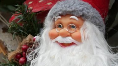 Yılbaşı süslerinin arka planında Noel Baba oyuncağı var..