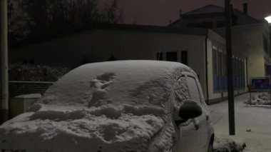 Gece Kış Şehri 'nin karla kaplı arabası. Akşam ıssız bir cadde..