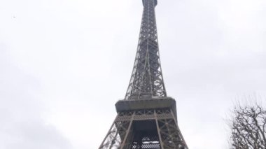 January 22, 2023 - Paris, France. Eiffel Tower in the daytime nearby, people tourists pass by.