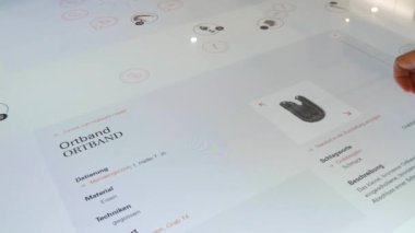 Karlsruhe, Germany - January 07, 2023: Interactive digital whiteboard table, in the history museum. A mans hand plays a game with historical finds. The latest technologies in education.