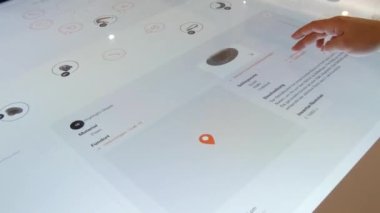 Karlsruhe, Germany - January 07, 2023: Interactive digital whiteboard table, in the history museum. A mans hand plays a game with historical finds. The latest technologies in education.