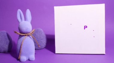 Mutlu Paskalyalar animasyonunu durdurun. Mor arka planda şirin mor tavşanlar belirir ve hareket eder. Paskalya kutlaması. Metin için şablon, boşluğu kopyala. Mutlu Paskalya yazıtları.