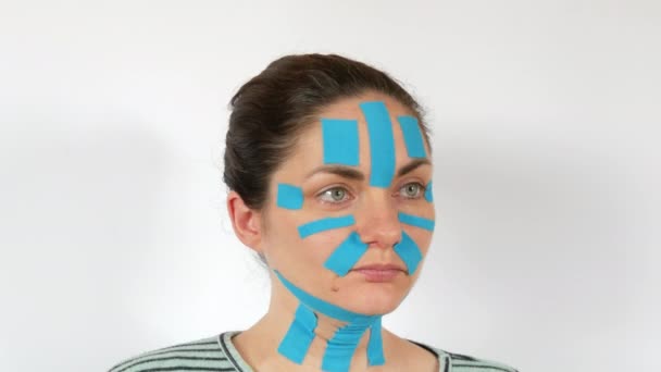 Genç Bir Kadın Açık Mavi Kinesio Şeritleri Sürmüş Yüzü Alnı — Stok video
