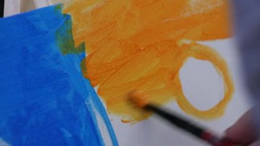 Çizim dersleri. Sanatçının biri stüdyoda fırçayla tuvale resim çiziyor..