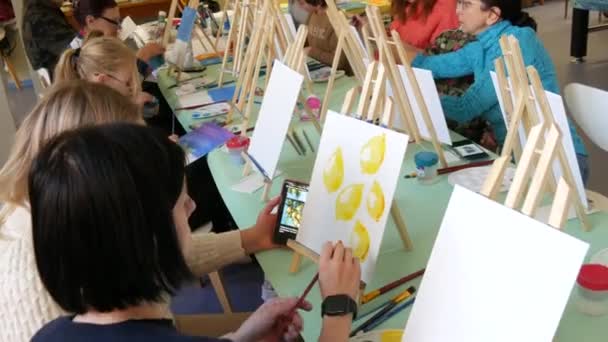 科索沃 2023年3月4日 一群成年人和儿童学习在画布上绘画 桌上有许多不同的油漆和刷子 汲取教训 — 图库视频影像