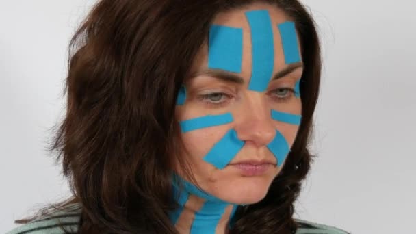 Young Woman Applied Light Blue Kinesio Strips Taping Face Forehead — Stock Video