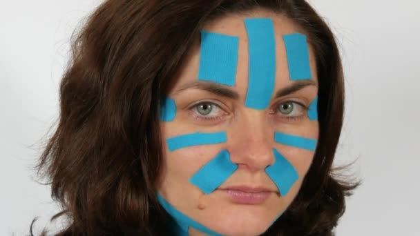 Mulher Jovem Aplicou Tiras Cinesio Azul Claro Gravando Rosto Testa — Vídeo de Stock