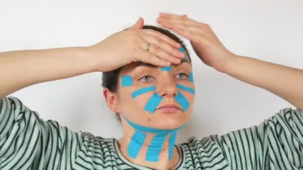 Genç Bir Kadın Açık Mavi Kinesio Şeritleri Sürmüş Yüzü Alnı — Stok video
