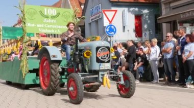 Buhl, Almanya - 11 Eylül 2022: Erik Hasadı Festivali. Şenlikli bir geçit töreni, dekore edilmiş bir traktör, resmi olarak caddede geziniyor, seyirci izliyor. Alman yazıtları