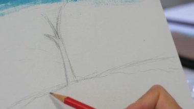 KEHL, GERMANY - 11 Mart 2023: Ressam bir el beyaz bir tuval üzerinde kurşun kalemle bir çizim dersi çizer.