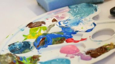 Çizim işlemi. Sanat stüdyosundaki bir masanın üzerindeki palette çeşitli resimler..