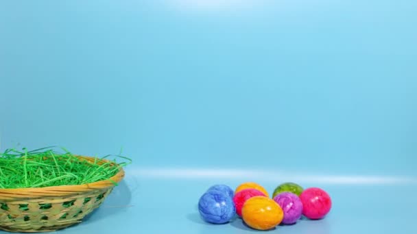 Zatrzymać Animację Ruchu Kolorowe Malowane Jajka Wskakują Wiklinowego Kosza Niebieskim — Wideo stockowe