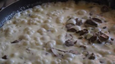 Mantarlı krema sosu ve yavaş çekimde köpüklü tavada pişirilmiş tavuk kalbi..