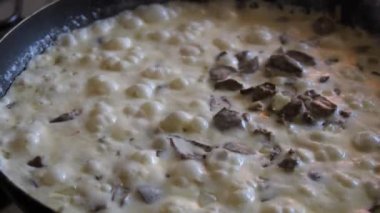 Mantarlı krema sosu ve yavaş çekimde köpüklü tavada pişirilmiş tavuk kalbi..