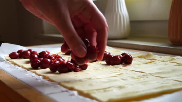 女性の手は生のスライスされた生地にチェリーベリーを産む ホームキッチンでパンやペストリー スローモーション — ストック動画