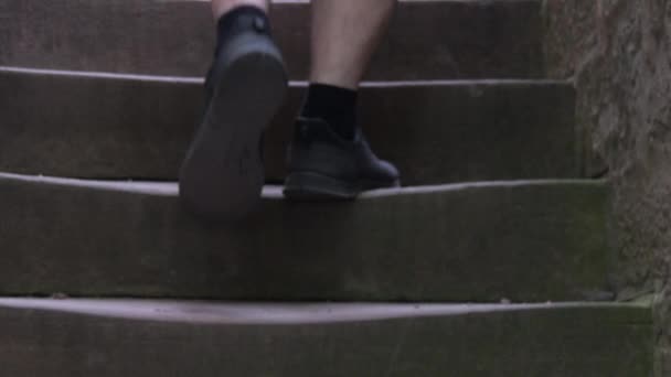 城のスローモーションで古い踏みつけ石の階段で人間の足が立ち上がる — ストック動画