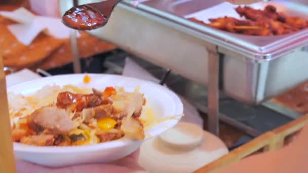 街头食物 在盘子里放了一大盘泰面 男子在食物节期间在亚洲面倒入酱汁 — 图库视频影像