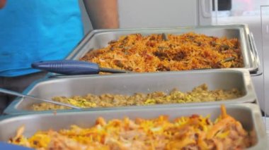 Sokak yemeği festivalinin tezgahında pilav ya da pilav olan büyük tabaklar..