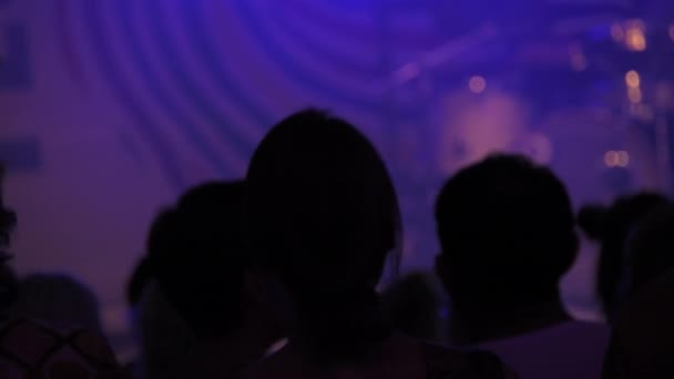 暗いスローモーションでコンサートで踊る人々のシルエット 人々はディスコで踊ってジャンプします 音楽クラブでの夜の楽しみ ナイトライフ 現代音楽 エンターテイメントのコンセプト — ストック動画