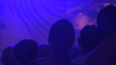Konserde yavaş çekimde dans eden insanların silueti. İnsanlar diskoda dans edip zıplıyorlar. Müzik kulübünde akşam keyfi. Gece hayatı, modern müzik ve eğlence konsepti.
