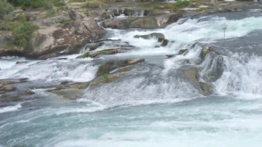 Büyük bir su akışı. Rhine Falls ağır çekimde. Dalgalar kayalara çarpıyor. Suyun doğasının gücü..