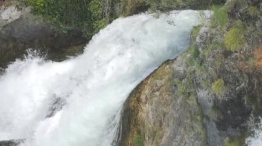 Büyük bir su akışı. Rhine Falls ağır çekimde. Dalgalar kayalara çarpıyor. Suyun doğasının gücü..