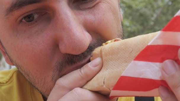 Młody Przystojniak Hot Dogi Apetytem Gryzie Bułkę Kiełbasę Fast Food — Wideo stockowe