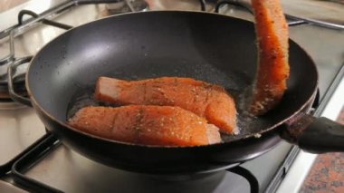 Baharatlı taze kırmızı balık filetosu tavada hazır. Somon fileto eti ayçiçeği yağında kızartılır, yakın çekim, yavaş çekim..