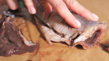 Ev mutfağında yavaş çekimde ringa balığı yiyen kadın eller..