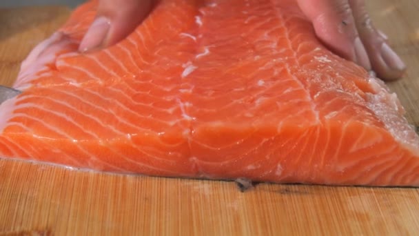 シェフはナイフで新鮮な赤い魚を満たしています ステーキのスローモーションのためのサーモン生肉を調理する 閉じるビュー — ストック動画