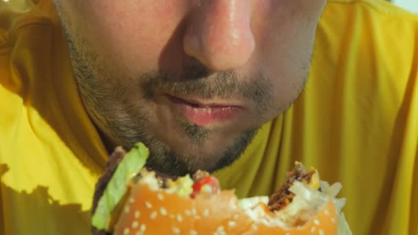 Giovane Con Una Maglietta Gialla Mangia Hamburger Hamburger Con Appetito — Video Stock