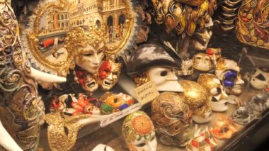 Venedik, İtalya - 5 Eylül 2023: Birçok inanılmaz güzel el yapımı Venedik karnaval maskeleri akşam saatlerinde bir mağaza vitrininde
