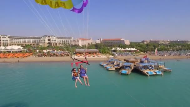 土耳其贝利克 2023年9月27日 一对快乐的夫妇乘坐降落伞在爱琴海的豪华酒店和海滨上空飞行 空中无人机视图 — 图库视频影像