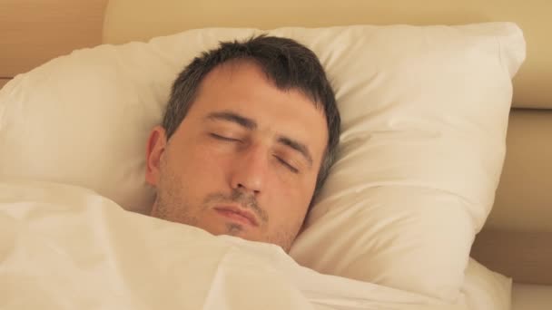 Jovem Dorme Quarto Hotel Uma Cama Branca Travesseiros Uma Pulseira — Vídeo de Stock