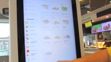 Kehl, Almanya - 17 Eylül 2023: Dijital düzen ekranı. Bir adam McDonalds restoranından sipariş veriyor..