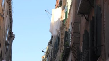 Venedik 'in dar sokakları. Evler birbirine yakın inşa edilir. Beyaz çarşaflar balkonda kuruyor..