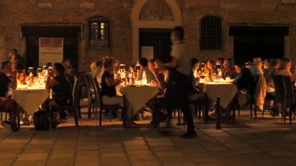 ヴェネツィア イタリア 2023年9月5日 居心地の良い 暖かい 暗い夜 人々はヴェネツィアの通りの一つで屋外のレストランに座っています ロマンチックにキャンドルが点滅するテーブルで — ストック動画