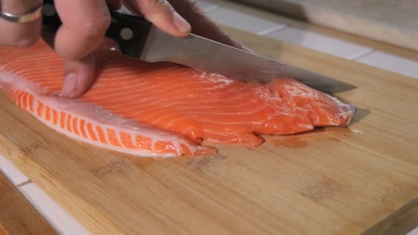 シェフはナイフで新鮮な赤い魚を満たしています ステーキのスローモーションのためのサーモン生肉を調理する 閉じるビュー — ストック動画