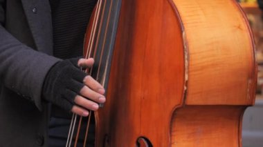 Çift bas gitar çalan bir sokak müzisyeninin elleri..