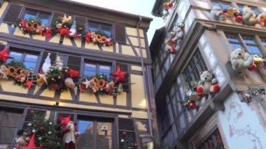 STRASBOURG, FRANCE - 3 ARALIK 2023: Ünlü bayram şenlik atmosferi için yarım keresteli evler Noel 'den önce büyük oyuncak ayılar ve çelenklerle süslenmiştir..