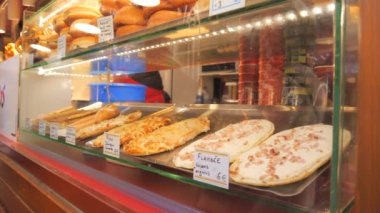 Bir sokak tezgahının camında bir dilim pizza ve turta alevi..