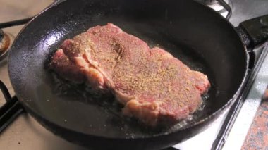 Baharatlı, tereyağlı ve sarımsaklı biftek yavaş çekimde tavada kızarır..