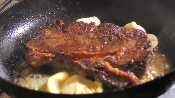 スパイスとバターとニンニクのビーフステーキをスローモーションで鍋に揚げる — ストック動画