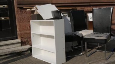 Eski püskü deri ve ahşap mobilyalar sokakta duruyor. Çöp yığınları, mobilyalar, eşyalar, ev eşyaları çöp kamyonuyla kaldırılmadan önce sokakta duruyordu..
