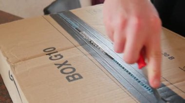 Kehl, Almanya - 10 Mayıs 2022: Amazon 'dan alınan bir paketin bıçakla kesilmesi. Kurye posta teslimatı. karton paket.