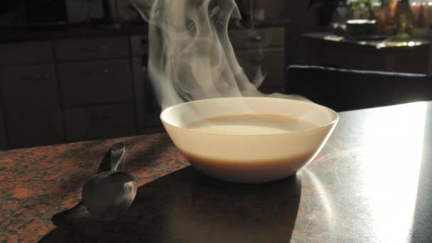 白色陶瓷盘 热汤蒸笼在厨房桌子上慢动作的近景 在金属勺子旁边 — 图库视频影像
