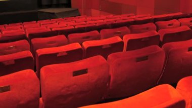 İnsanlar olmadan boş bir Kızıl Sinema salonu ve bir film. Sinema salonunda boş ve rahat koltuklar..