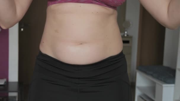 女性腹部身体呈阳性 女人慢动作地跳肚皮舞 身穿运动胸罩和腿的妇女腹部有少量脂肪 健康生活方式或超重的概念 — 图库视频影像