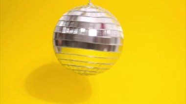 Sarı zemin üzerinde hareket eden bir disko topunun hareket animasyonunu durdur.
