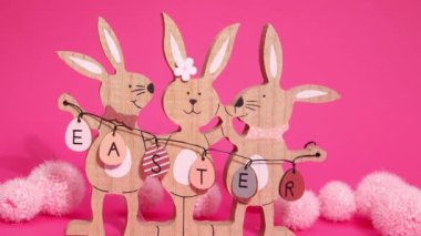 Paskalya Hareketi animasyonu. Güzel Paskalya tavşanları çerçevede hareket ediyorlar. Pembe arka planda Paskalya tabelasını tutuyorlar..